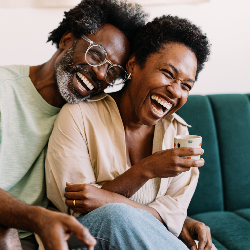 Happy adults smiling together on sofa
