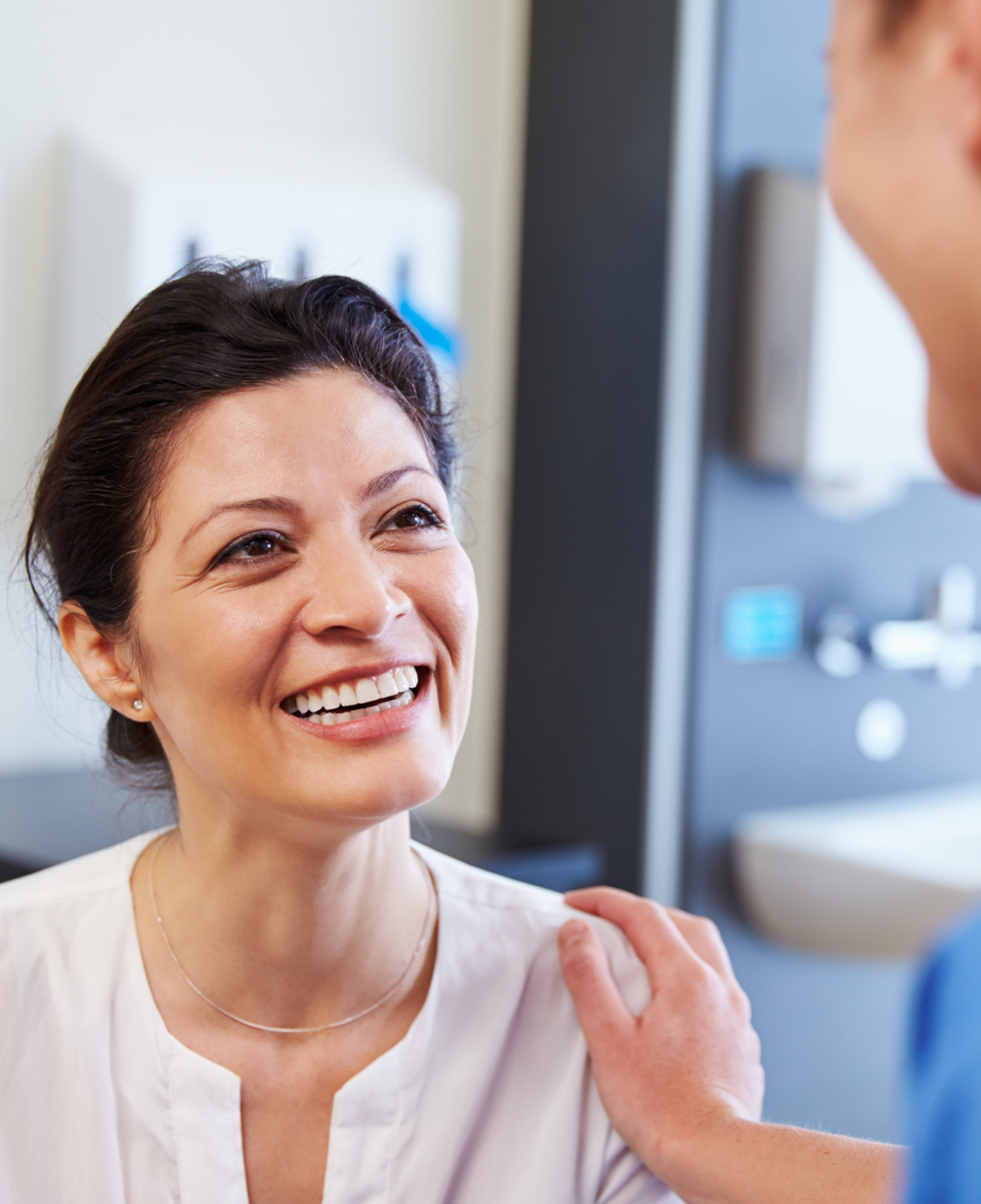 Smiling patient speaking with an oral surgeon during a dental consultation.