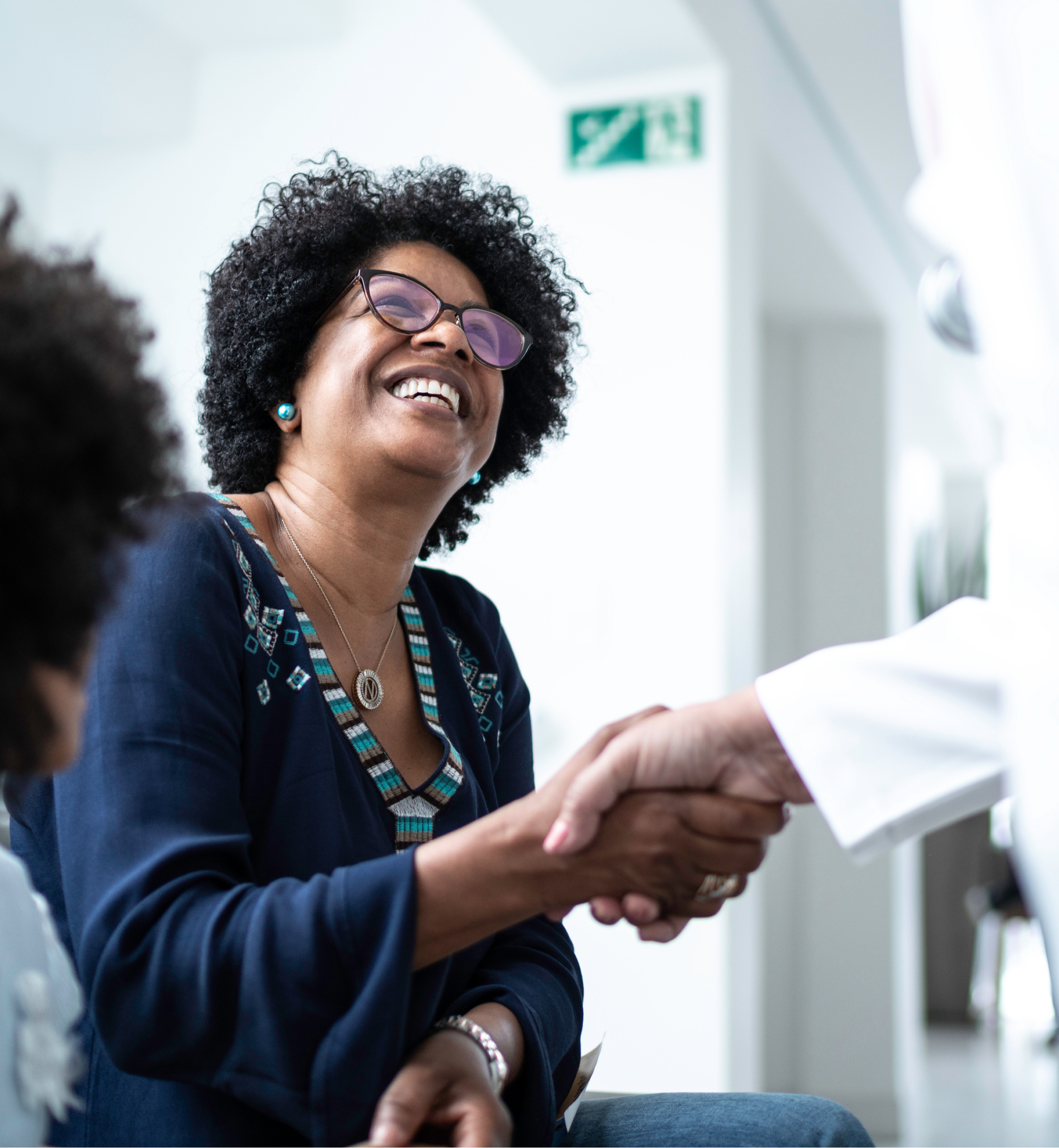 Dentist warmly shaking hands with a smiling patient during a dental consultation, creating a welcoming and comfortable experience at the dental office.